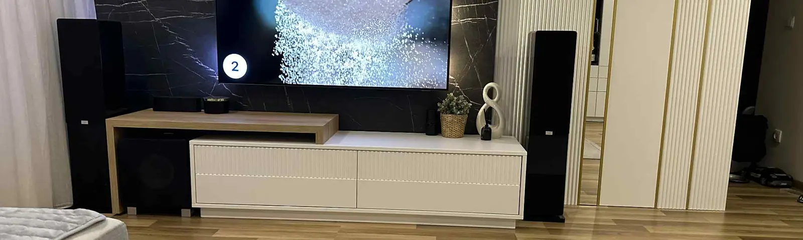 Zabudowa ściany telewizyjnej z ryflowanym panelem i podświetlanymi półkami